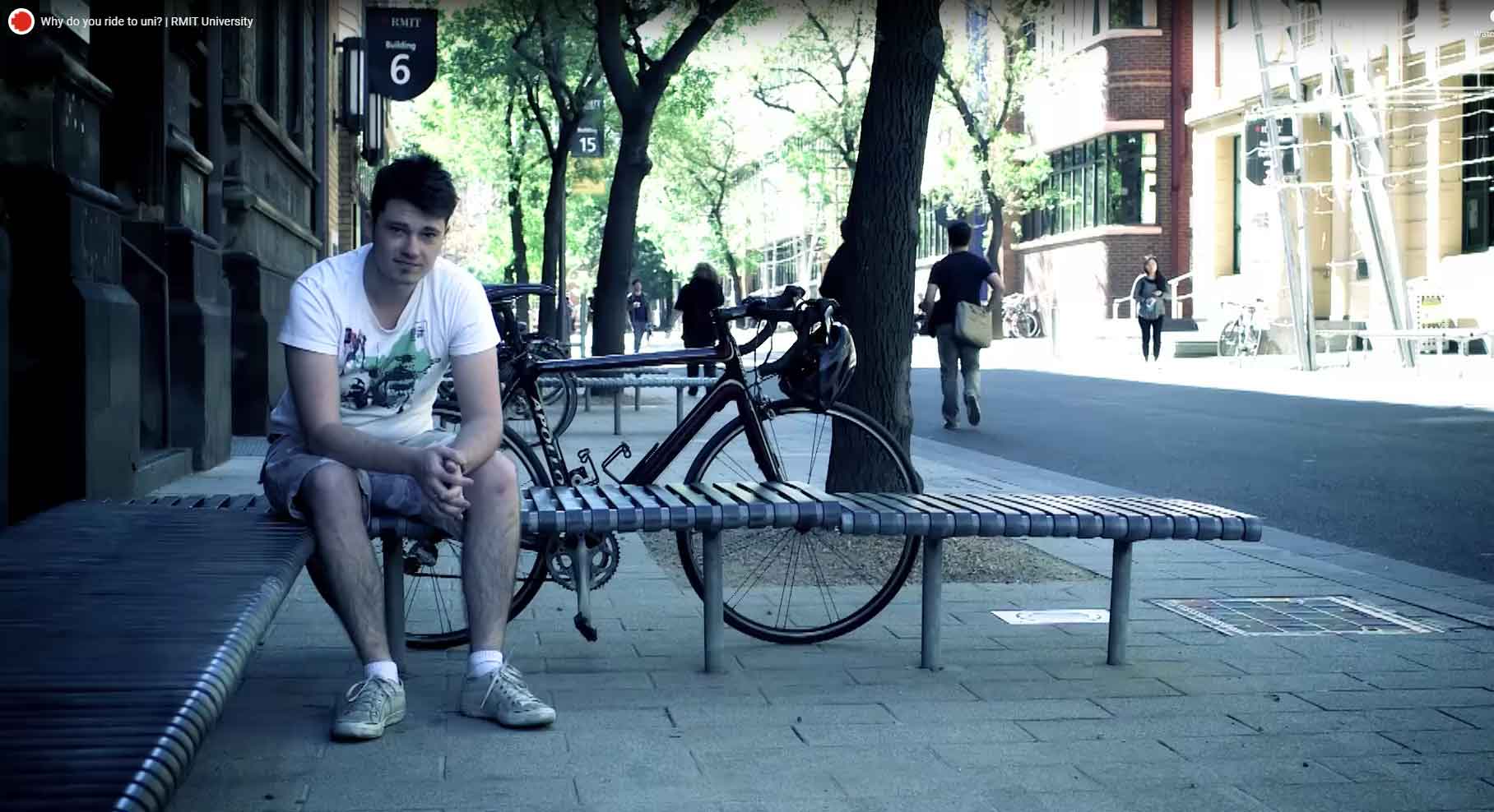 Image of student outside RMIT building with his bike